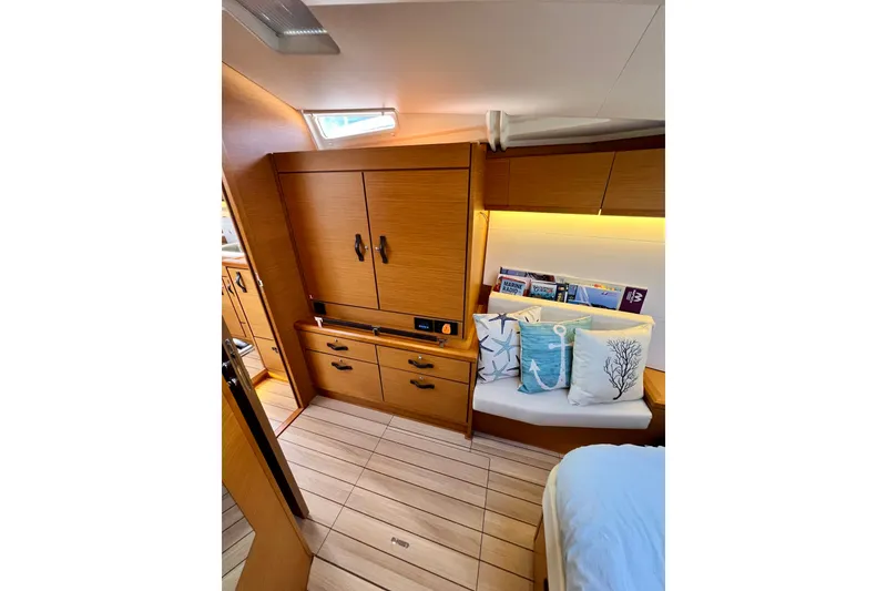 Slide: The Image of Luxurious interior of 2018 Jeanneau 54 yacht with wooden cabinetry and decorative pillows. - 76