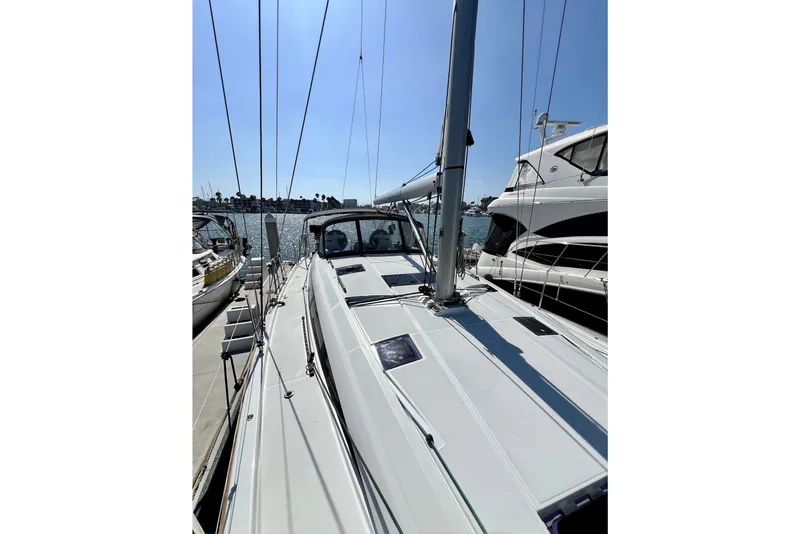 Slide: The Image of 2018 Jeanneau 54 sailboat docked at marina, clear sky, calm waters. - 21