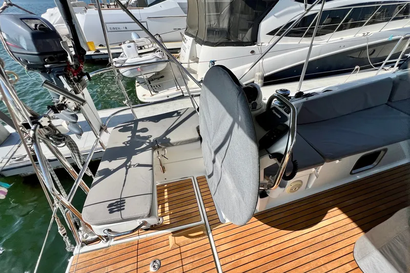 Slide: The Image of Cockpit of 2018 Jeanneau 54 yacht with teak decking and cushioned seating at marina. - 32