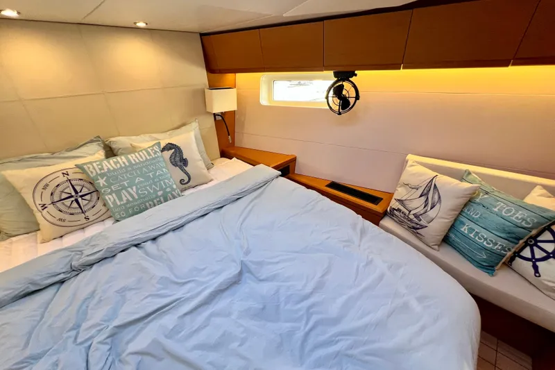 Slide: The Image of Cozy cabin interior of 2018 Jeanneau 54 yacht with nautical-themed pillows and soft lighting. - 73