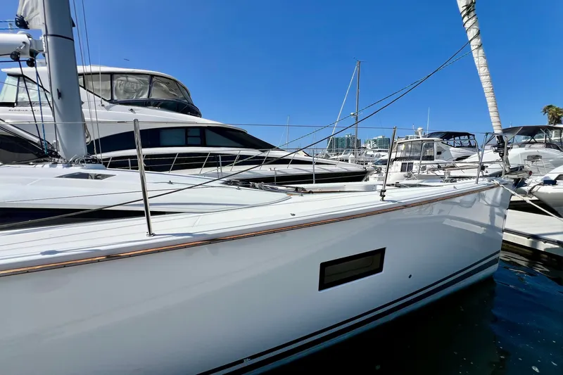 Slide: The Image of 2018 Jeanneau 54 yacht docked in marina under clear blue sky. - 13
