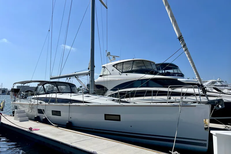 The Image of 2018 Jeanneau 54 sailboat docked at marina under clear blue sky. - 0
