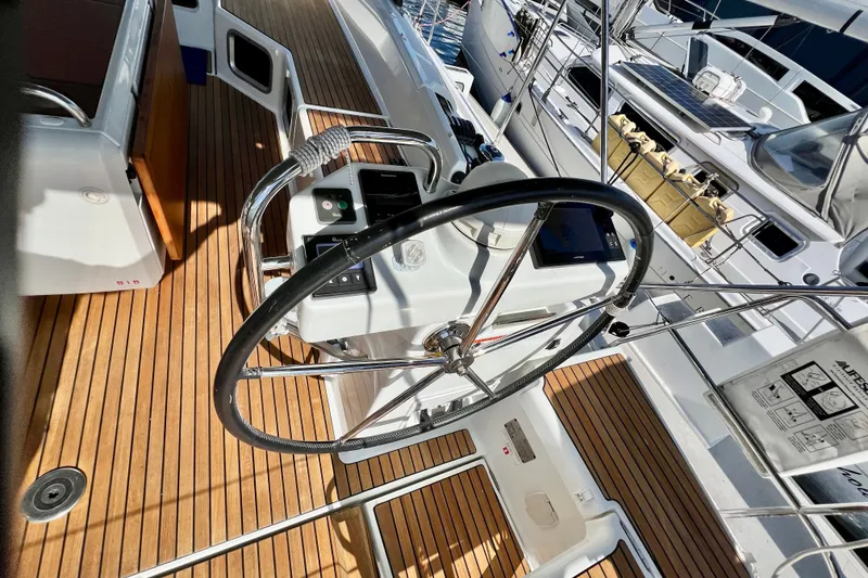 Slide: The Image of Steering wheel of a 2018 Jeanneau 54 yacht with teak deck and navigation controls. - 33
