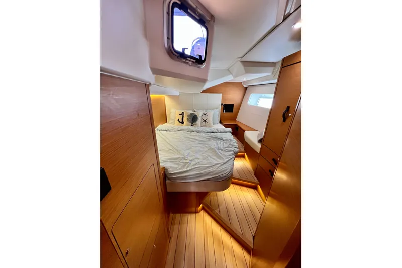 Slide: The Image of Luxurious cabin interior of 2018 Jeanneau 54 yacht with cozy bed and wooden finish. - 91