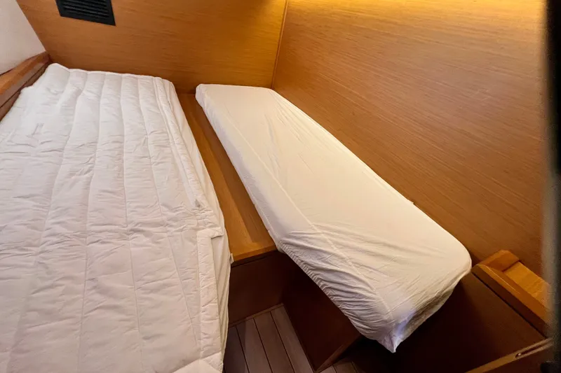 Slide: The Image of Interior cabin of 2018 Jeanneau 54 yacht with twin beds and wooden paneling. - 84