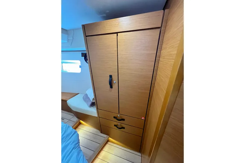 Slide: The Image of Interior of 2018 Jeanneau 54 yacht featuring a wooden wardrobe and cozy seating area. - 94