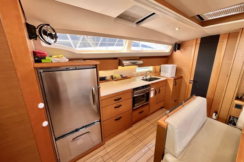 Slide: The Image of Luxurious 2018 Jeanneau 54 yacht interior kitchen with modern appliances and sleek wood finish. - 42
