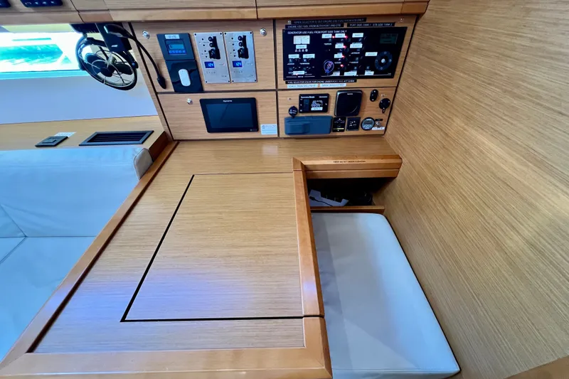 Slide: The Image of Interior view of a 2018 Jeanneau 54 yacht's navigation station with control panels. - 58