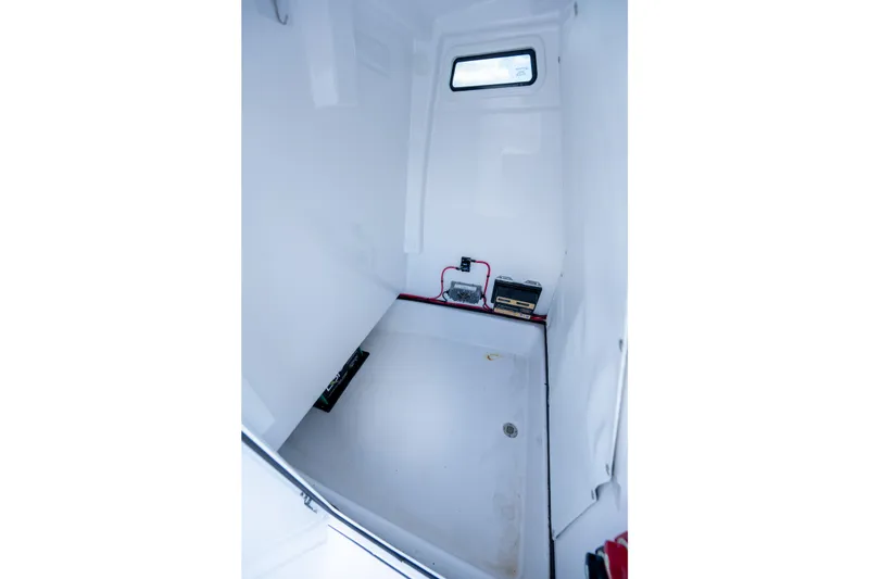 Slide: The Image of 2024 Sportsman Masters 247OE Bay Boat interior compartment with wiring and equipment. - 18
