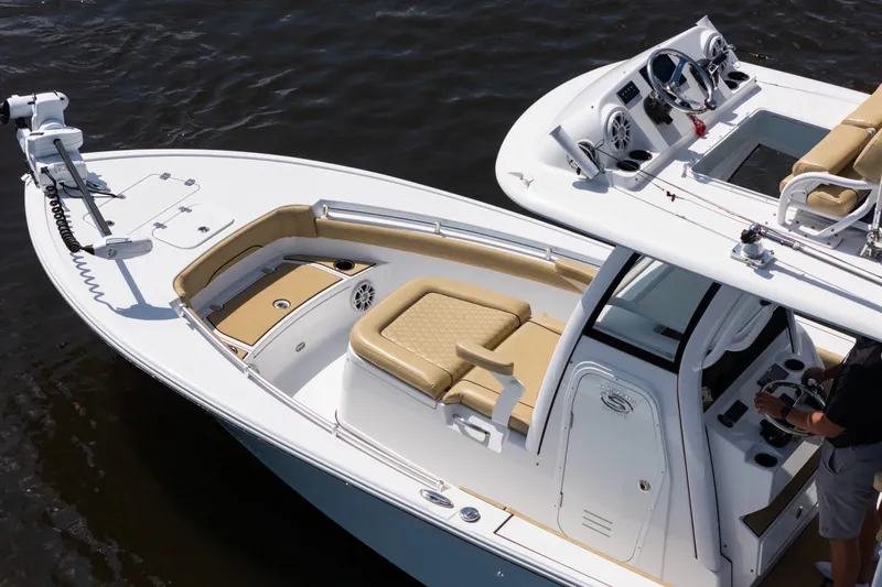 Slide: The Image of 2024 Sportsman Masters 247OE Bay Boat with tan seating and modern controls on water. - 17
