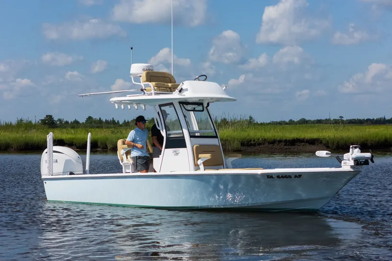 Slide: The Image of 2024 Sportsman Masters 247OE Bay Boat cruising on calm water under blue sky. - 2