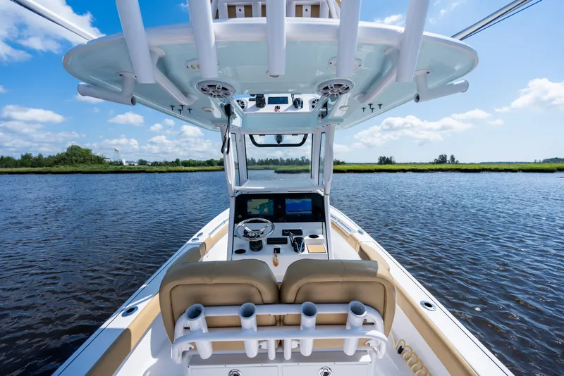 Slide: The Image of 2024 Sportsman Masters 247OE Bay Boat on calm water, showcasing helm and seating. - 13