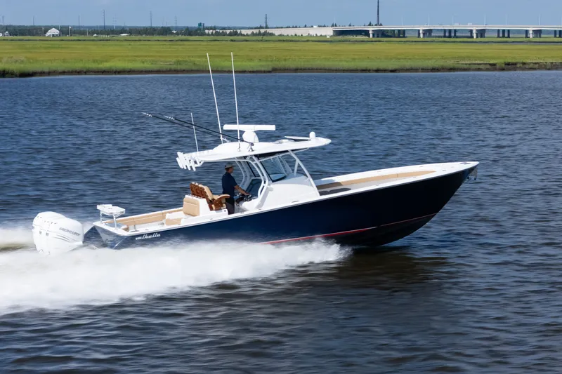 The Image of 2023 Valhalla Boatworks V-37 cruising on a calm river with lush green banks. - 0