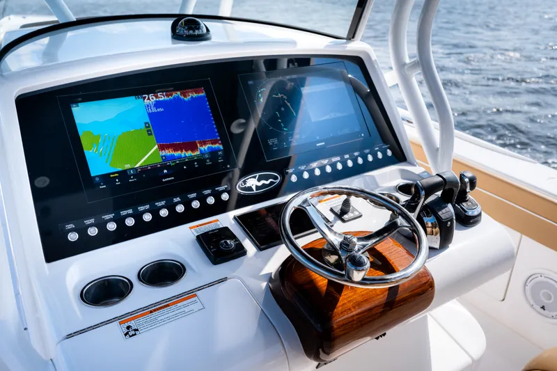 Slide: The Image of 2023 Valhalla Boatworks V-37 helm with dual displays and steering wheel on open water. - 22