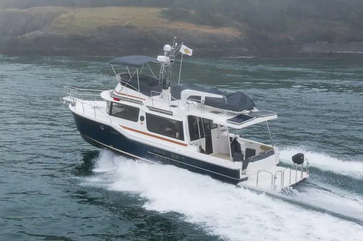 Slide: The Image of Manufacturer Provided Image: 2025 Ranger Tugs R-43 CB cruising on water, side view. - 2