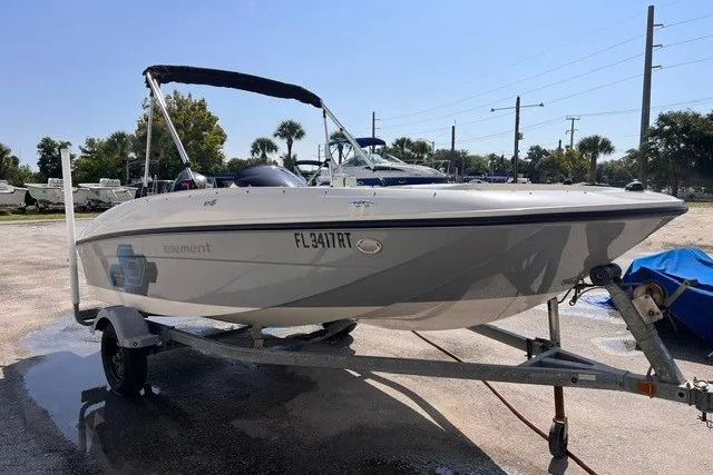 The Image of 2018 Bayliner Element E16 boat on trailer, parked outdoors under clear sky. - 0