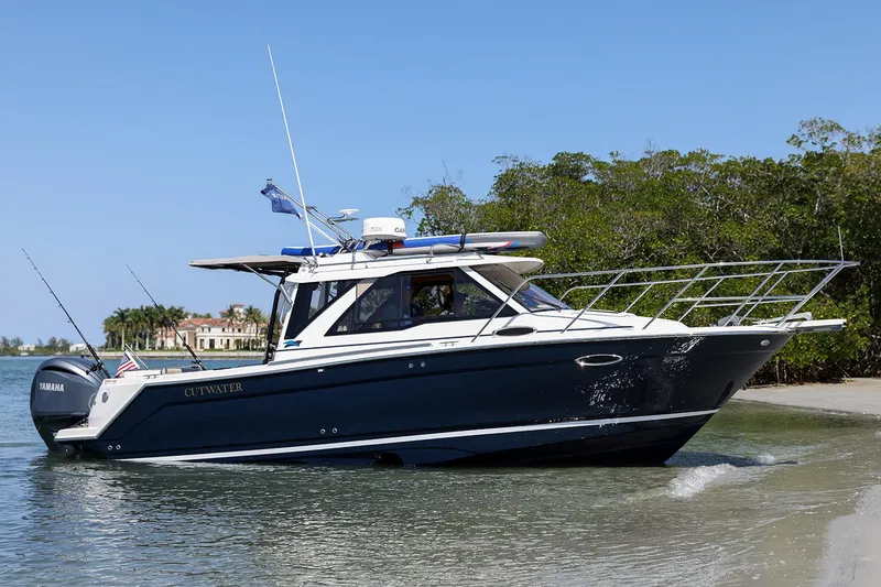 Slide: The Image of Manufacturer Provided Image: 2025 Cutwater C-248 Coupe boat cruising near shoreline with clear blue sky. - 2