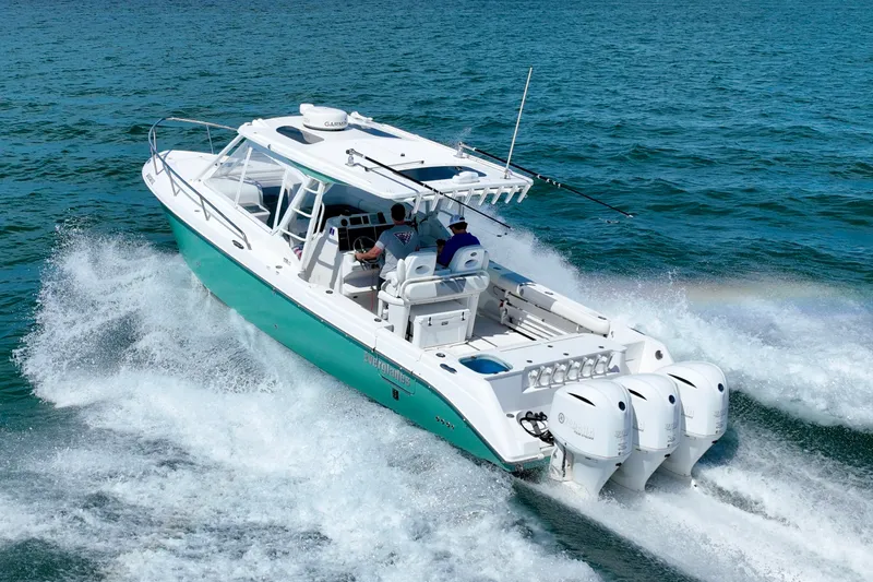 Slide: The Image of A 2016 Everglades 350LX boat speeds across blue water, featuring three outboard engines. - 13