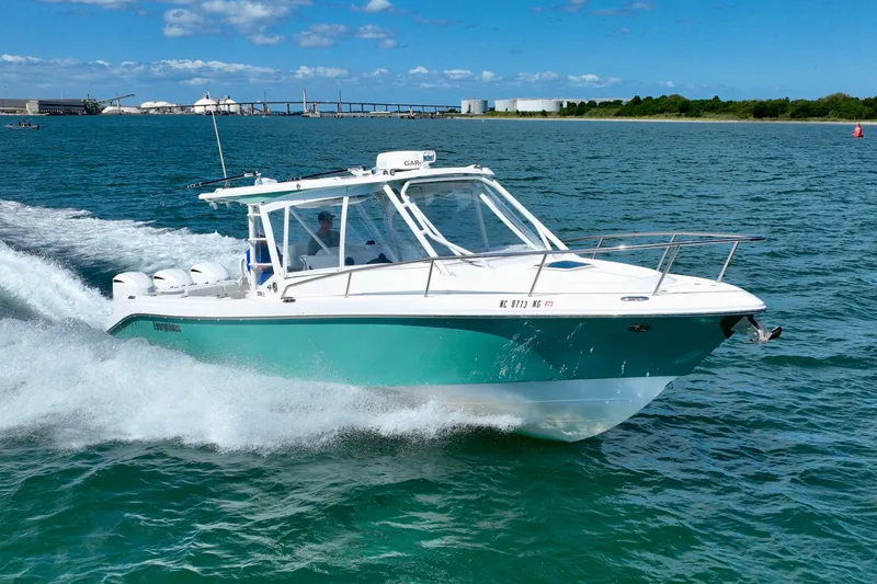 Slide: The Image of A 2016 Everglades 350LX boat speeds across the water under a blue sky. - 14