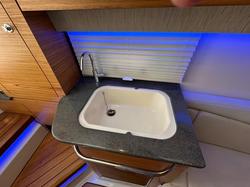Slide: The Image of Luxury sink area on 2022 Boston Whaler 380 Realm boat with modern design and blue lighting. - 36