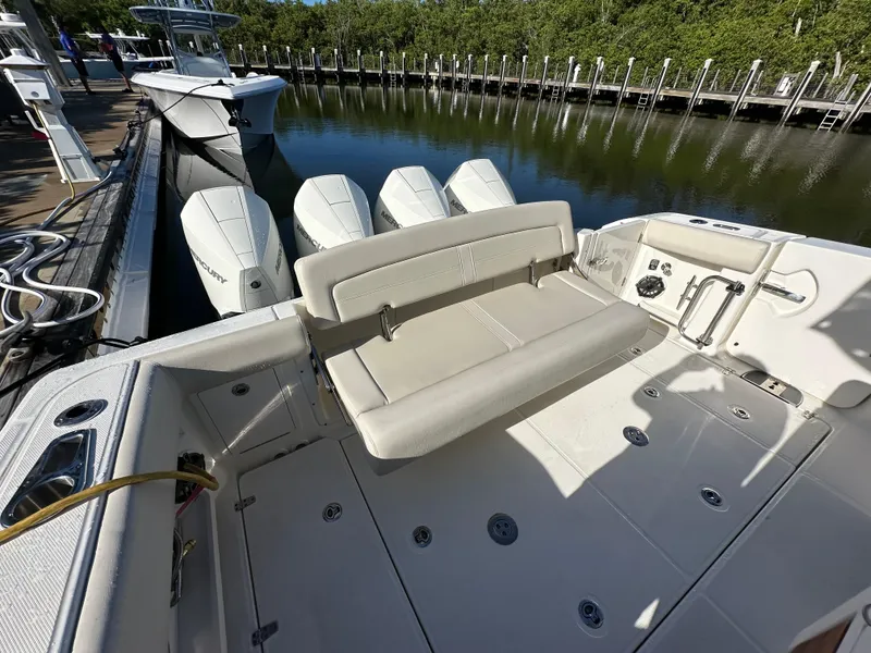 Slide: The Image of 2022 Boston Whaler 380 Realm boat with triple Mercury engines, docked in a marina. - 6