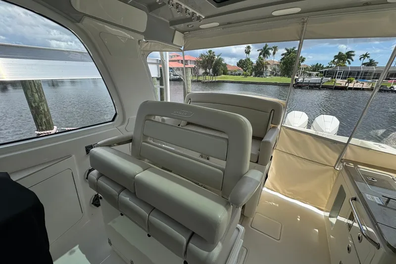Slide: The Image of Interior view of 2022 Boston Whaler 380 Realm boat with luxurious seating and waterfront backdrop. - 14