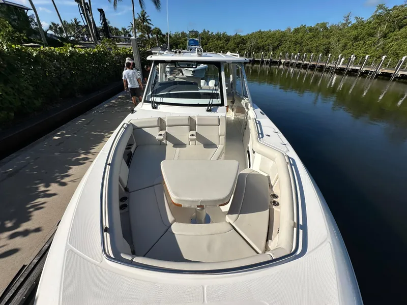 Slide: The Image of 2022 Boston Whaler 380 Realm boat docked, featuring spacious seating and sleek design. - 23