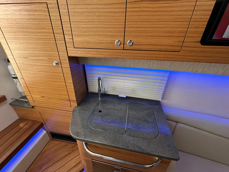 Slide: The Image of 2022 Boston Whaler 380 Realm interior with wooden cabinetry and modern sink area. - 35