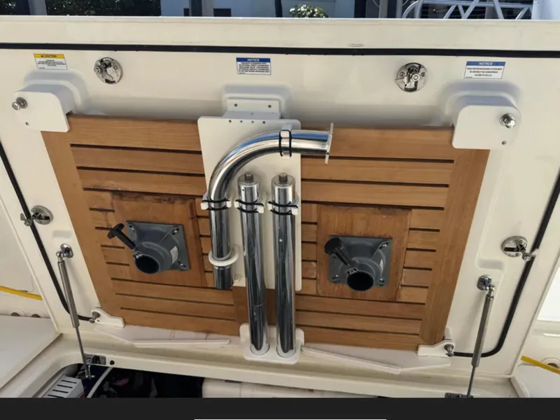 Slide: The Image of The image shows the stern of a 2022 Boston Whaler 380 Realm with wood paneling and metal pipes. - 40