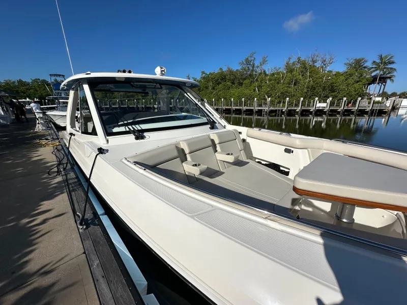 Slide: The Image of 2022 Boston Whaler 380 Realm boat docked, featuring sleek design and spacious seating area. - 9