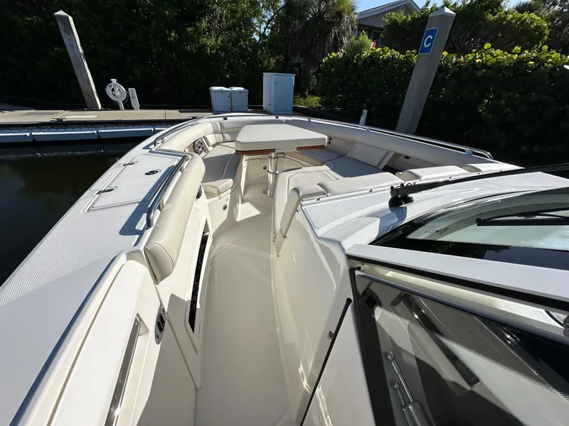 Slide: The Image of 2022 Boston Whaler 380 Realm boat interior with seating and table at dock. - 21