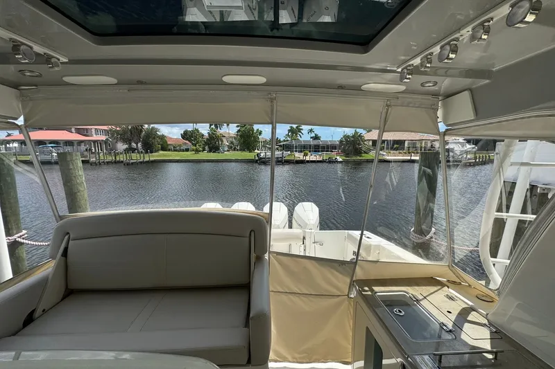 Slide: The Image of Interior view of 2022 Boston Whaler 380 Realm boat, featuring seating and waterfront backdrop. - 16