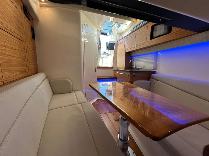 Slide: The Image of Interior of 2022 Boston Whaler 380 Realm with wood accents and ambient lighting. - 37