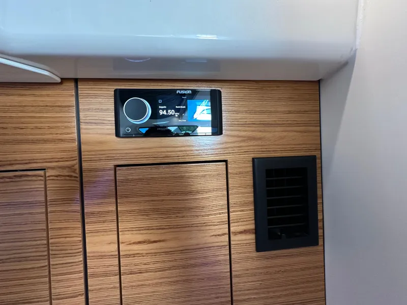 Slide: The Image of 2022 Boston Whaler 380 Realm interior with Fusion stereo system and wood paneling. - 38