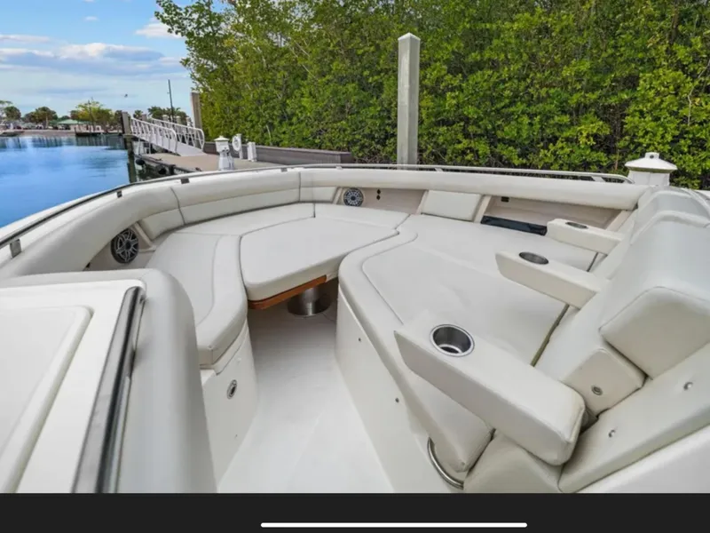 Slide: The Image of Boston Whaler 380 Realm 2022: Spacious seating area with white upholstery, surrounded by water and trees. - 42
