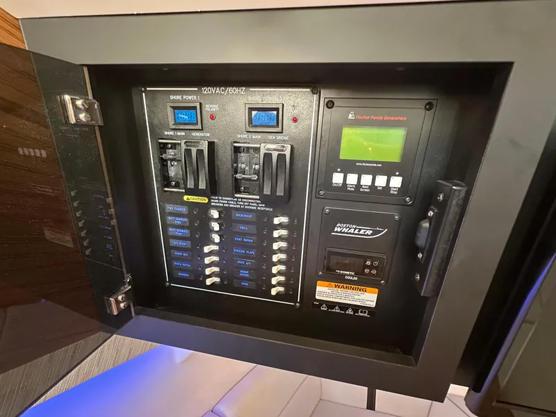 Slide: The Image of Electrical control panel on 2022 Boston Whaler 380 Realm boat, featuring switches and displays. - 32
