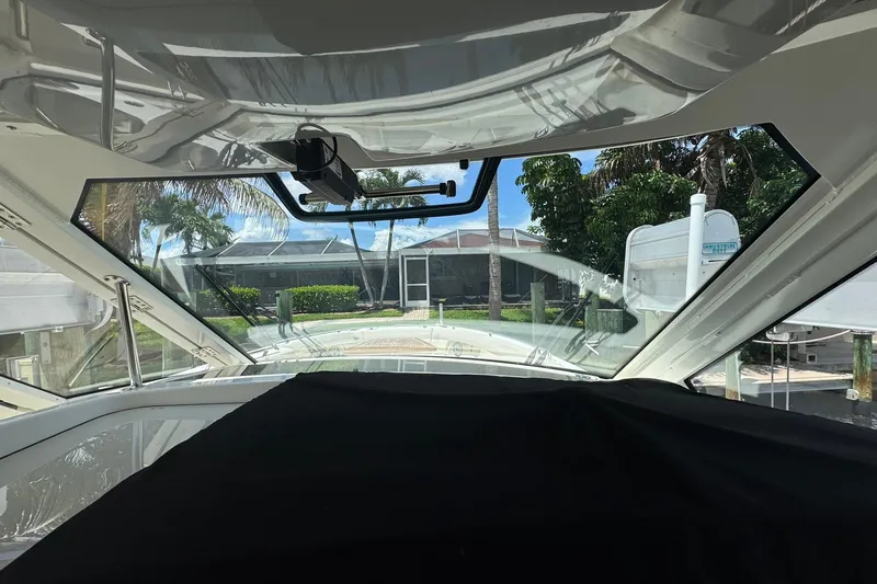 Slide: The Image of Interior view from a 2022 Boston Whaler 380 Realm boat, showcasing the windshield and outdoor scenery. - 46