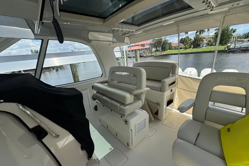 Slide: The Image of Interior of 2022 Boston Whaler 380 Realm boat with luxurious seating and waterfront view. - 17