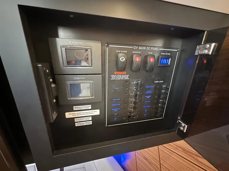 Slide: The Image of 12V main DC panel on 2022 Boston Whaler 380 Realm boat, showing switches and voltage display. - 33