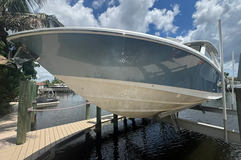 Slide: The Image of 2022 Boston Whaler 380 Realm boat docked, showcasing sleek design under a cloudy sky. - 43