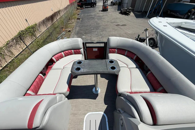 Slide: The Image of 2023 Bennington 23 LX pontoon boat interior with plush seating and central table. - 13
