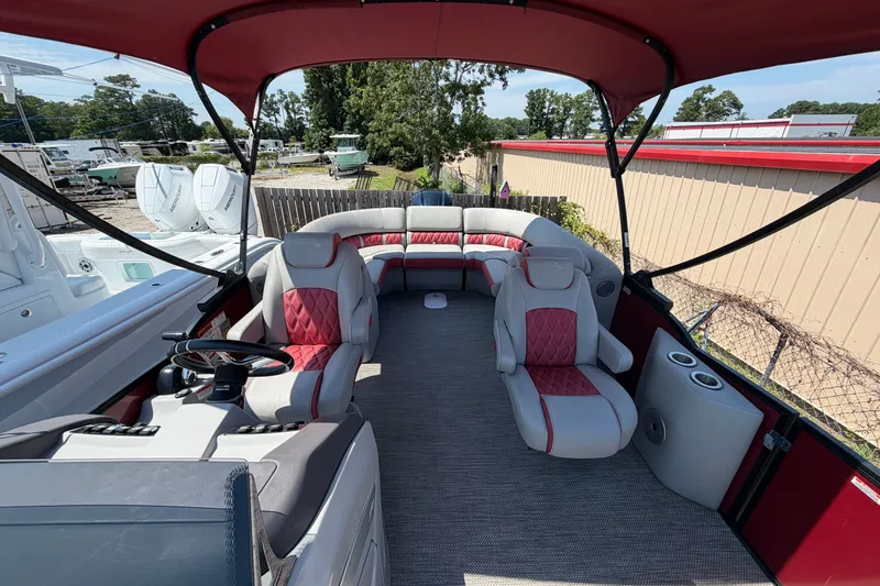 Slide: The Image of 2023 Bennington 23 LX pontoon boat interior with red and gray seating under canopy. - 14