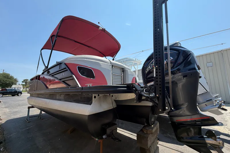 Slide: The Image of 2023 Bennington 23 LX pontoon boat with red canopy and powerful outboard motor. - 19