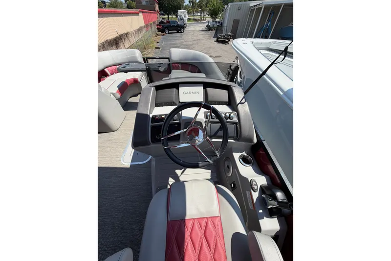 Slide: The Image of 2023 Bennington 23 LX boat interior with steering wheel and seating area. - 15