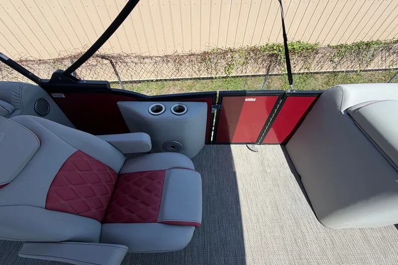 Slide: The Image of 2023 Bennington 23 LX boat interior with red and gray seating and cup holders. - 17