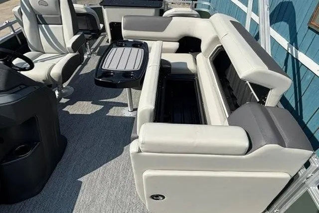 Slide: The Image of 2026 Sun Tracker Fishin' Barge 22 DLX interior with seating and table. - 16