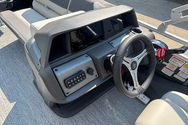 Slide: The Image of 2026 Sun Tracker Fishin' Barge 22 DLX steering console with modern controls and seating. - 18
