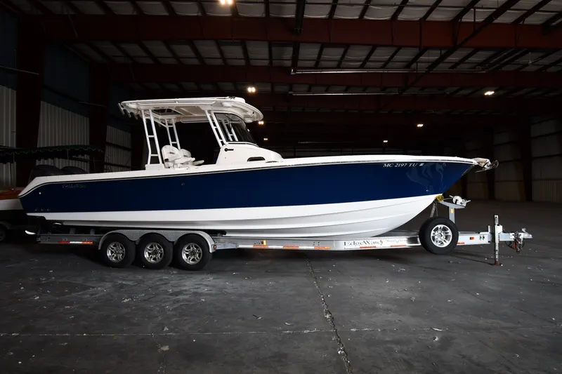 The Image of 2015 Edgewater 320CC boat on trailer in indoor storage facility. - 0