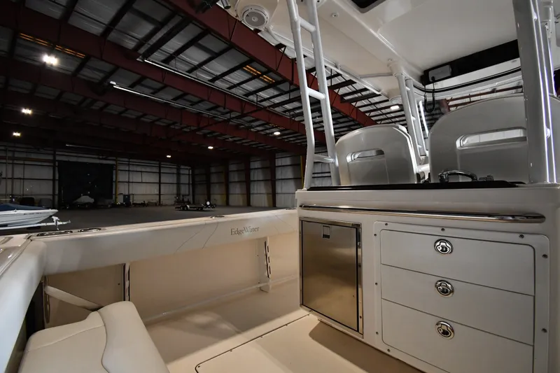 Slide: The Image of 2015 Edgewater 320CC boat interior in a spacious warehouse setting. - 14