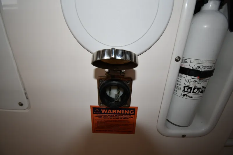 Slide: The Image of 2015 Edgewater 320CC boat electrical outlet with warning label and fire extinguisher. - 39